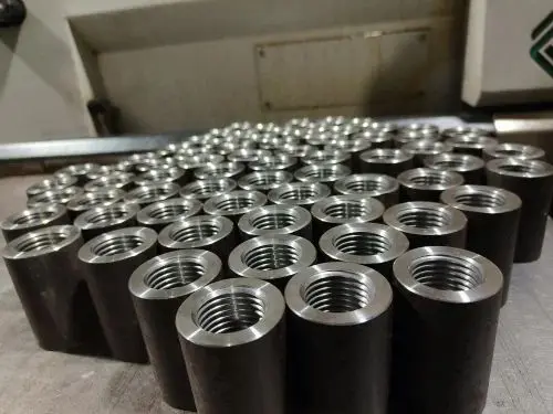 DD TECH precision-finished rebar couplers arranged in production-ready batches